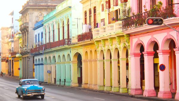 Classic old cars and traditional colorful buildings in downtown Havana, Cuba